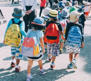 colorful group of children wearing backpacks at summer camp